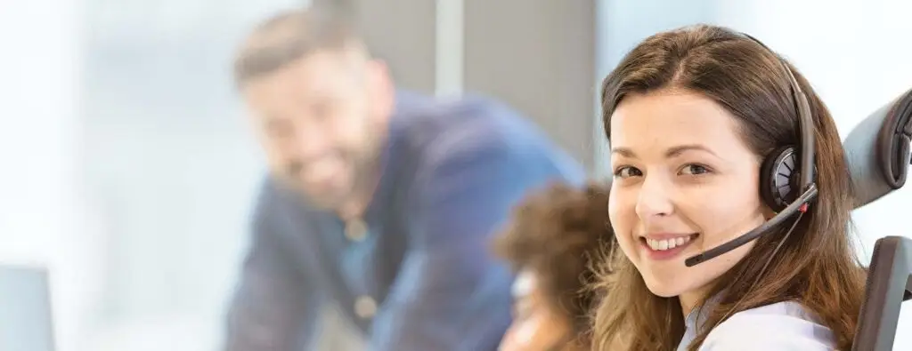 Smiling woman in focus with blurred people in the background.