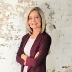 Professional woman in a maroon blazer smiling confidently.
