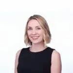 Smiling woman with blonde hair in a black sleeveless top.