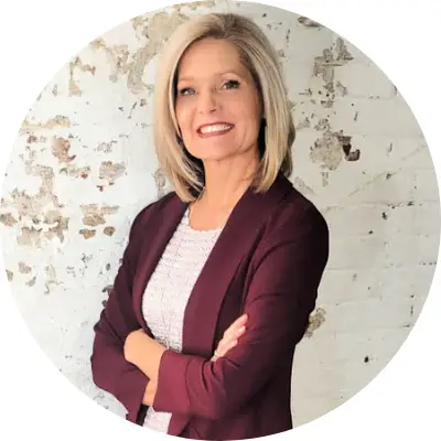 Professional woman smiling confidently with arms crossed.