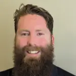 Smiling man with a full beard and short hair.