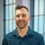 Smiling man in casual shirt posing indoors.