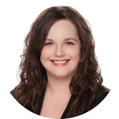 Smiling woman with curly brown hair and red lipstick.