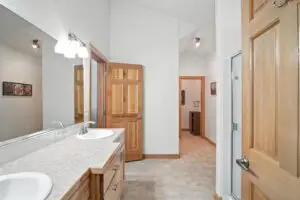 Bright bathroom with wooden cabinetry and large mirror.
