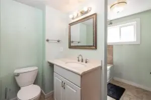 Modern bathroom with vanity, mirror, and toilet.