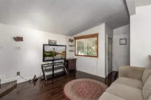 Cozy bedroom with a TV, desk, and a round rug by the window.