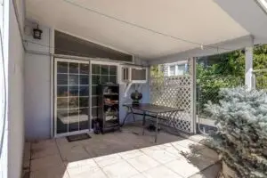Cozy outdoor patio with seating and a barbecue grill under a covered area.