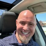 Smiling man sitting in a car.